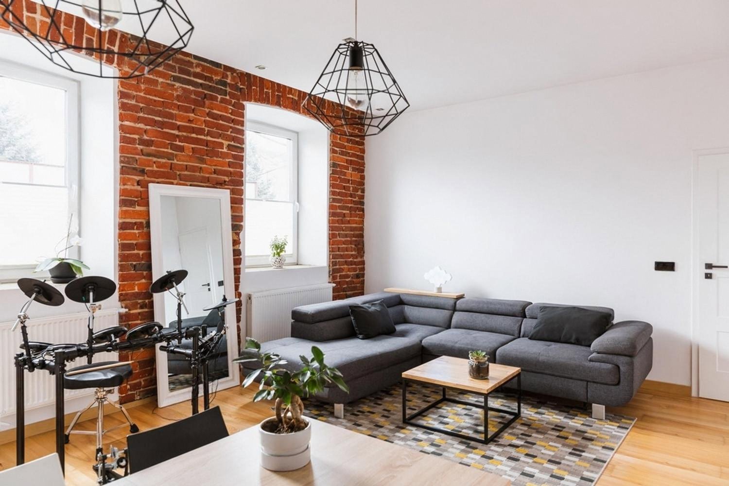 Open-plan living room in a private house with tall windows and an exterior door